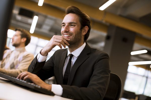 Successful young businessman uses laptop in office